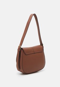 Bolso de hombro de cuero marrón con superficie texturizada, con forma curva, ribete negro y una correa desmontable con detalles en acabado dorado.