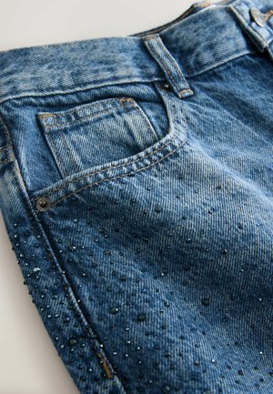 Blaue Denim-Jeans mit einem ausgewaschenen Finish und Perlenverzierungen. Verfügt über ein klassisches Fünf-Taschen-Design und einen Metalldruckknopfverschluss.