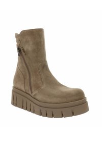 Bottine en daim beige avec une semelle plateforme épaisse, fermeture éclair latérale et des détails texturés à l'intérieur et sur le bord inférieur.