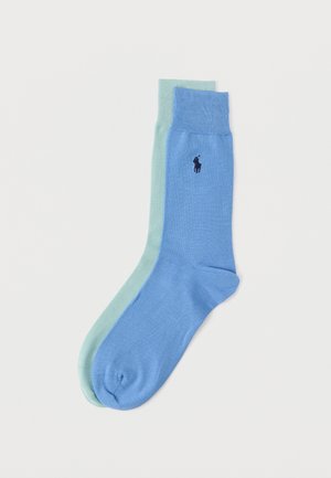 Par de calcetines lisos de caña corta en azul claro y verde menta, con logo bordado en azul oscuro de un caballo y jinete en el calcetín azul.