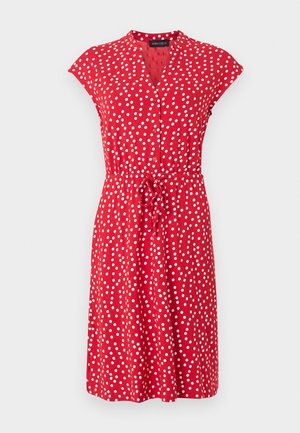 Κόκκινο φόρεμα μήκους μέχρι το γόνατο με λευκές πουά, κοντά μανίκια τύπου κάπ, κουμπωτό μπροστινό μέρος και ζώνη στη μέση.