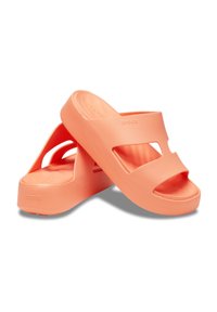 Orangene Gummisandalen mit dickem Plateau, offenen Zehen und ausgeschnittenen Designs an den Seiten. Strukturiertes Fußbett für zusätzlichen Halt.