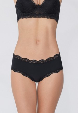 Schwarze Unterhosen mit Spitzenbesatz, aus glattem Stoff gefertigt, mit einem floralen Spitzenbund und Beinöffnungen, die einen nahtlosen Look verleihen.