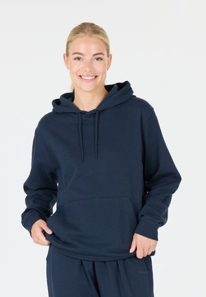 Mörkblå hoodie gjord av mjukt material, med en framficka, ribbade ärmslut och en avslappnad passform.