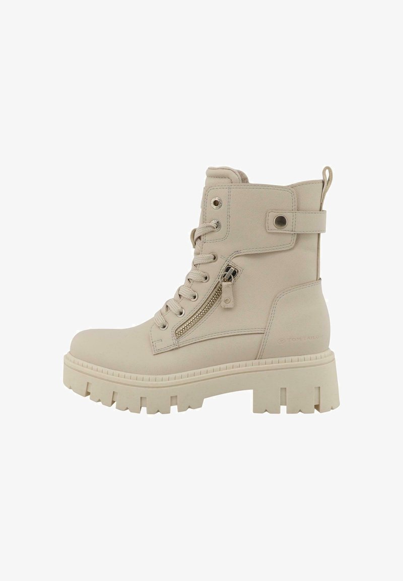 Beżowe botki za kostkę o gładkim skórzanym wykończeniu, z suwakiem z przodu, sznurowanym fasonem oraz grubą, wytrzymałą podeszwą z wyciętymi detalami.