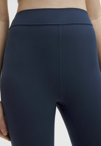 Navy blue high-waisted leggings with a smooth, stretchy texture. Features flat seams and a sleek design without visible branding or patterns.