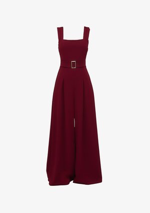 Tuta bordeaux con gambe ampie, scollo quadrato e cintura con fibbia quadrata. Realizzata in un tessuto liscio e strutturato.