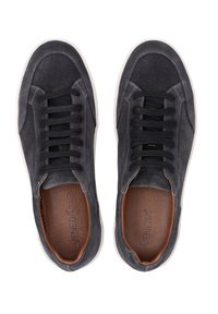 Šedé semišové tenisky s černými tkaničkami, bílou gumovou podrážkou a hnědým koženým stélkou. Mají kontrastní švy a zaoblenou špičku.