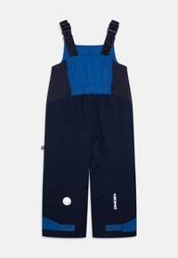 Nātrija zilās ūdensnecaurlaidīgās kombinezoni ar regulējamiem siksnām, elastīgu jostu un kontrastējošām zilo akcentiem. Iespējas atstarojošs logotips un velcro aproces.