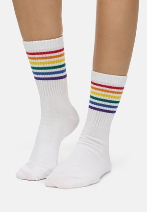 Weiße Knöchelsocken mit bunten Streifen in Rot, Orange, Gelb, Grün, Blau und Lila am oberen Rand. Rippstruktur, mittlere Dicke.