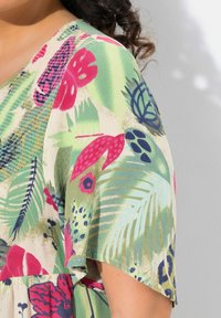 Blumenmusterstoff in Grün-, Pink- und Marineblau-Tönen; leicht und mit lockerer Passform sowie kurzen Ärmeln. Strukturierten Oberfläche mit gemischtem Laub.