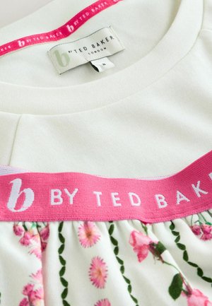 Lichtgroen top met een roze band met de tekst "b by TED BAKER". Bloemenpatroon met roze bloemen en groene bladeren aan de onderkant. Zachte textuur.