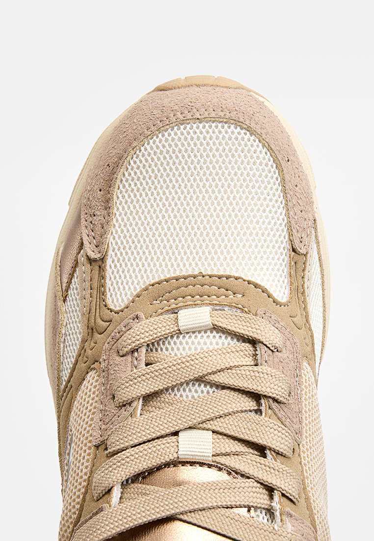 Beige Sneaker aus Netz- und Wildledermaterialien, mit runder Zehenform, Schnürdesign und gepolsterter Zunge. Verfügt über metallische Akzente und strukturierte Details.