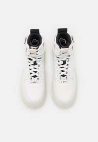 Weiße High-Top-Sneaker mit einem Obermaterial aus glattem Leder, Stoffakzenten, schwarzer Zunge und strukturiertem Profil. Verfügt über ein Schnürsystem und ein Branding-Detail.
