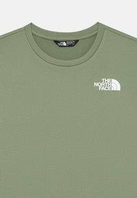 T-shirt verde oliva realizzato in tessuto morbido, con colletto rotondo e maniche corte. La parte anteriore presenta un logo bianco sul lato sinistro del petto.