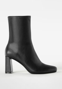 Schwarze knöchelhohe Stiefel aus glattem Leder, mit quadratischer Zehenpartie und einem klobigen, geometrischen Blockabsatz. Nahtloses Design mit minimalen Akzenten.