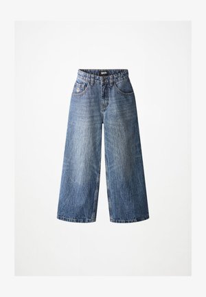 Džíny z modrej denimovej látky s vysokým pásom a širokými nohavicami, s prednými vreckami a malým vyšitým symbolom mieru na pravom vrecku.