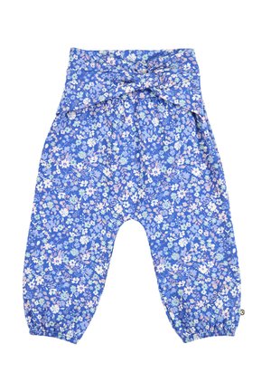 Niebieskie luźne spodnie dziecięce z pastelowym, kwiatowym nadrukiem, elastycznymi mankietami przy kostkach oraz szerokim paskiem zawiązanym na kokardę z przodu.