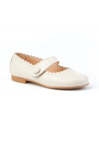 Zapato Mary Jane de cuero crema claro con un borde ondulado, correa ajustable con cierre de botón y una suela baja y plana de goma.