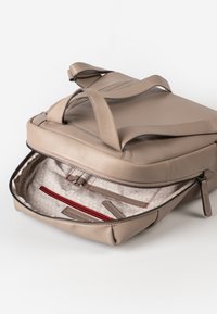 Beige Leder Tasche mit zwei oberen Griffen und einem Reißverschlussöffnung. Das Innenleben hat ein helles Muster und eine rote Reißverschlusstasche mit Kartenfächern.