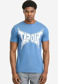 Blaues Baumwoll-T-Shirt mit einem großen weißen "TAPOUT"-Logo auf der Brust. Kurzärmlig, Rundhalsausschnitt und figurbetontes Design.