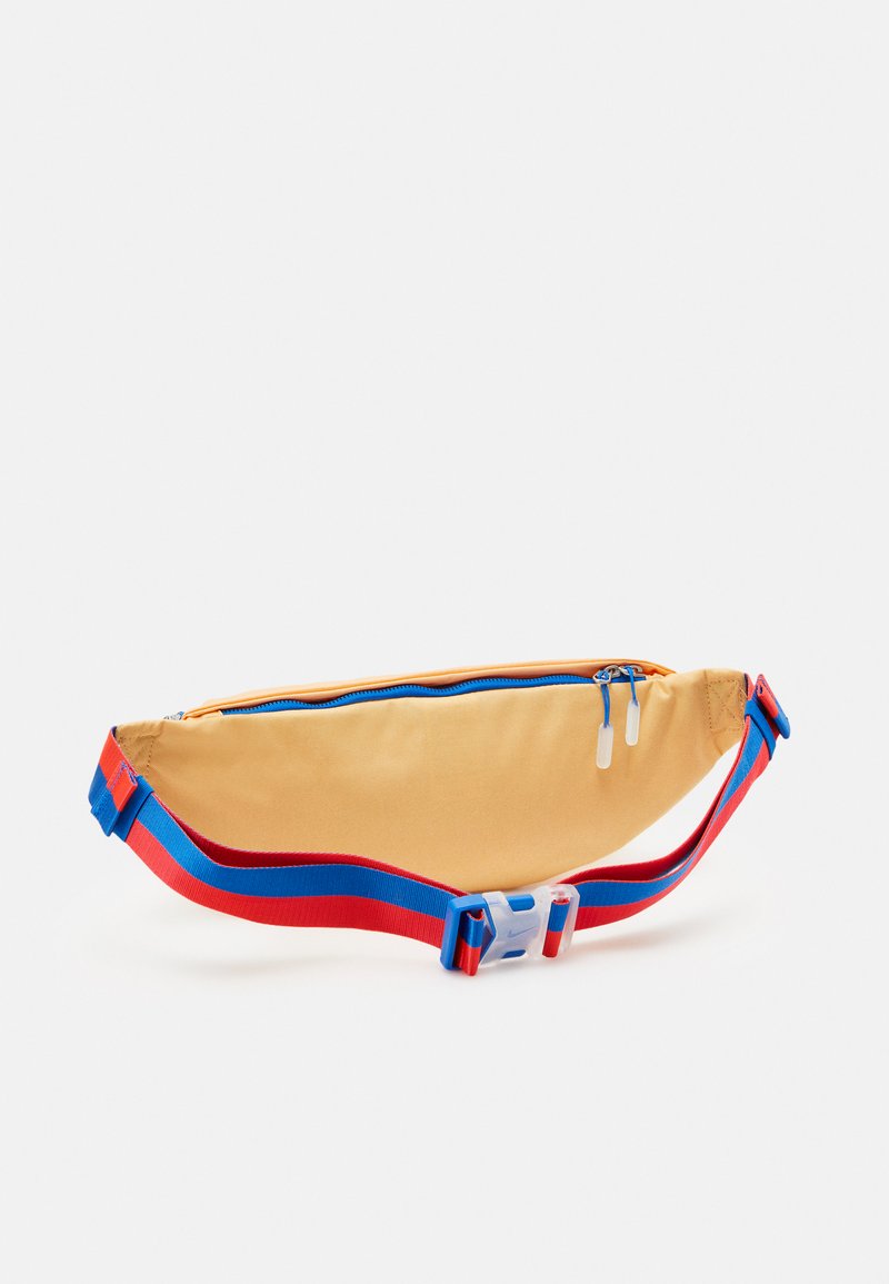 Sac banane en tissu jaune avec une fermeture éclair bleue et des sangles ajustables rouges. Il dispose d'un seul compartiment zippé pour le rangement.