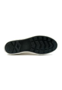 Semelle en caoutchouc noir avec des motifs de grip texturés, dotée d'un intercalaire blanc et d'un logo circulaire. Contours pour traction et stabilité.