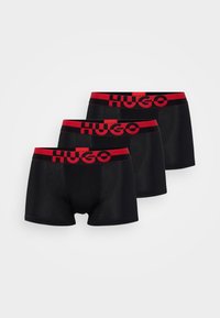 Black boxer shorts set of three, featuring red elastic waistband with 'HUGO' branding. Smooth fabric and fitted design.
