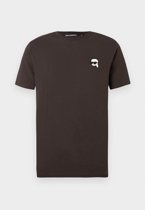 T-shirt de algodão castanho com decote redondo. Apresenta um pequeno gráfico branco de um rosto com óculos de sol na área do peito esquerdo.