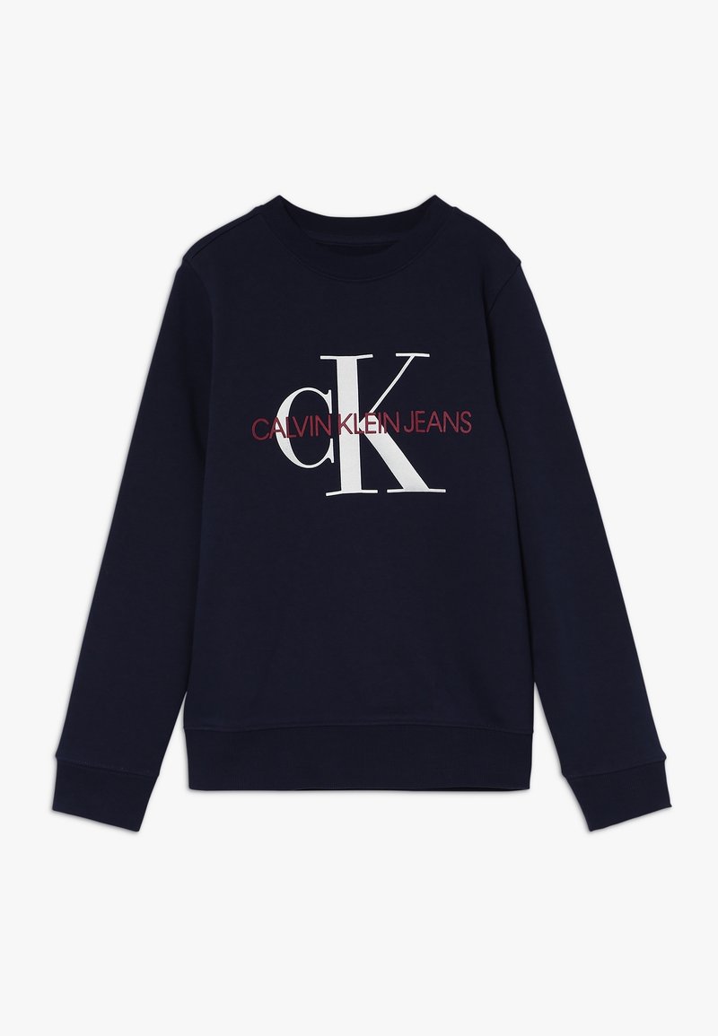 Sudadera de cuello redondo en color marino, fabricada en algodón, que presenta un gran logotipo en blanco "CK" con el texto "CALVIN KLEIN JEANS" en rojo debajo. Puños y dobladillo acanalados.