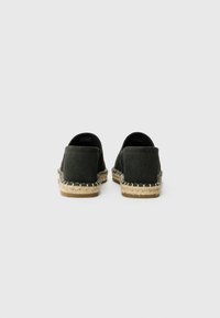 Sorte ruskind espadriller med en flettet jutesål og forstærket hæl. Bagfra ses den lave snit og den bløde tekstur.