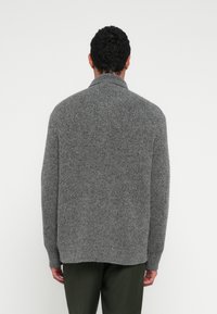 Γκρι πλεκτό πουλόβερ με ψηλό γιακά, ριμπ μανσέτες και τελείωμα. Διαθέτει υφή υφάσματος για επιπλέον ζεστασιά και ανοιχτό σχέδιο άνετης εφαρμογής.