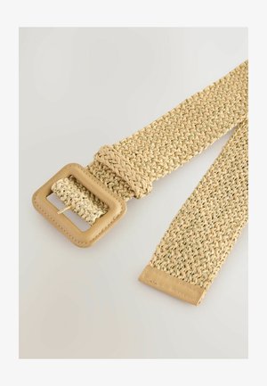 Tkana slamnata remen u bež boji sa četvrtastom metalnom kopčom. Odlikuje se teksturiranom površinom i kožnim detaljima na kopči i krajevima.