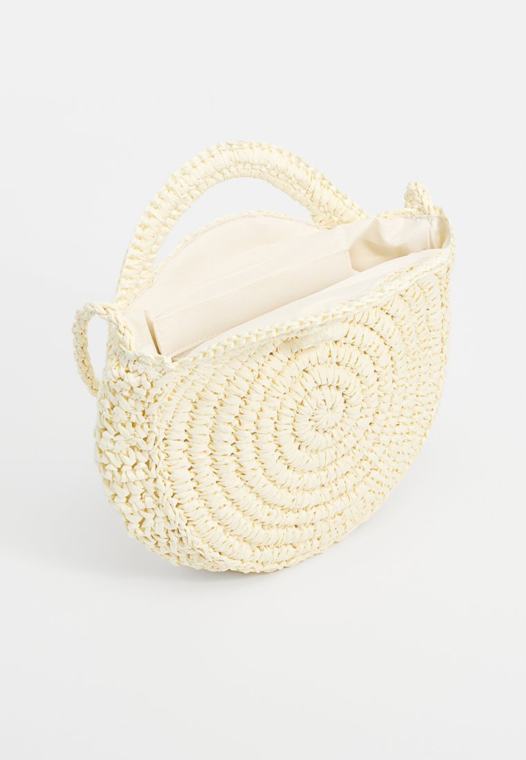 Bolso redondo de rafia en color amarillo claro con un acabado texturizado. Presenta dos asas y un interior forrado y abierto para un fácil acceso.