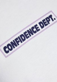T-shirt en coton blanc avec "CONFIDENCE DEPT." en texte bleu marine en gras dans un contour rectangulaire violet clair. Texture lisse.