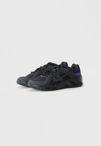 Melnas sporta kurpes ar acu tīklojumu, ar teksturētām detaļām un kontrastējošām zila krāsas akcentiem. Iespējams melns "swoosh" logotips un izturīga gumijas zole.