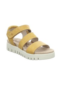Yellow leather sandal with three wide straps, beige cushioned insole, and white chunky sole with ridges. Provides open-toe design.