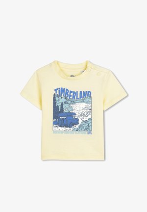 Gelbes T-Shirt mit kurzen Ärmeln und einem blauen Grafikdesign, das einen LKW, Berge und Wasser zeigt, mit dem Schriftzug "Timberland" und einem Outdoor-Motiv.