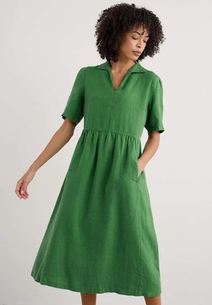 Green linen short-sleeved dress with a collared neckline, flared skirt, and side pockets. Smooth texture and mid-length design.