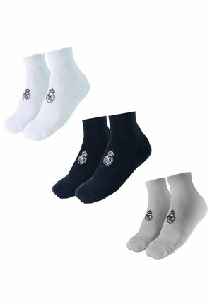 Pary białych, czarnych i szarych skarpetek do kostek, każda z małym haftowanym logo Real Madrid w pobliżu kostki.