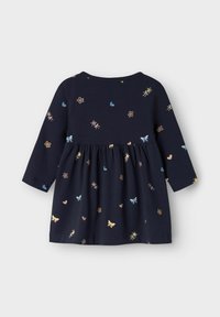 Vestido de manga larga en color navy con patrones de flores y corazones en tonos pastel. Hecho de una tela suave, con un escote redondo y cintura fruncida.