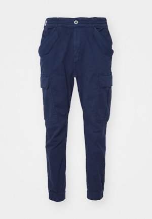 Pantaloni cargo blu navy in cotone con vita elastica, due tasche laterali e tasche cargo su ogni gamba. Vestibilità affusolata alla caviglia.