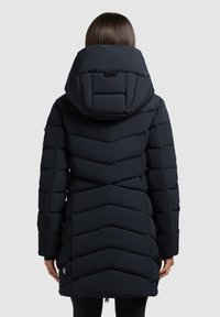 Pikk must puffjakker chevron-tikkimisega, kapuutsiga ja lukuga. Omab diskreetset logo alumises servas ja tekstureeritud viimistlust.