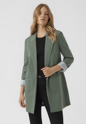Světle zelený blazer s jednoradovým designem, s klopami a manžetami s pruhovaným vzorem. Kapsy na bocích.