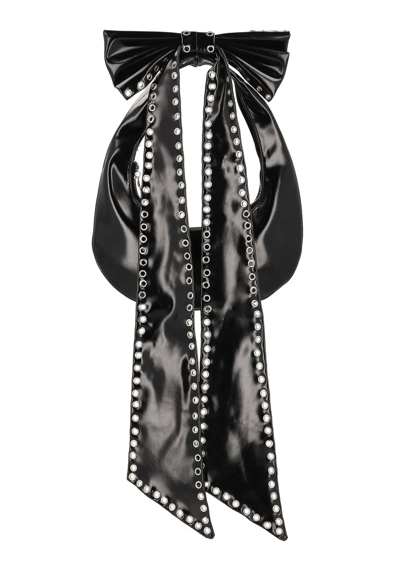 Černá kabelka z lakované kůže s velkou mašlí nahoře a dvěma dlouhými pásky připomínajícími stuhy. Okraje a otvory lemují stříbrné cvoky.