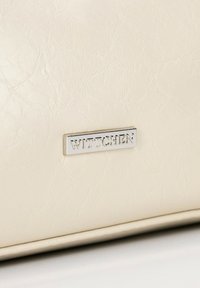 Cremefarbene Geldbörse aus strukturiertem synthetischem Material, mit einer silbernen rechteckigen Logo-Plakette mit dem Markennamen "WITTCHEN."