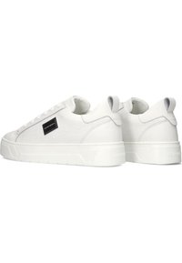 Witte sneakers met een gestructureerd, krokodillenpatroon, gladde leren accenten, een dikke witte zool en een klein zwart logo detail.