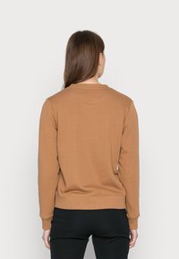 Braunes Langarm-Sweatshirt aus weichem Stoff mit Rundhalsausschnitt und gerippten Bündchen. Die Rückseite zeigt ein schlichtes Design ohne sichtbare Logos.