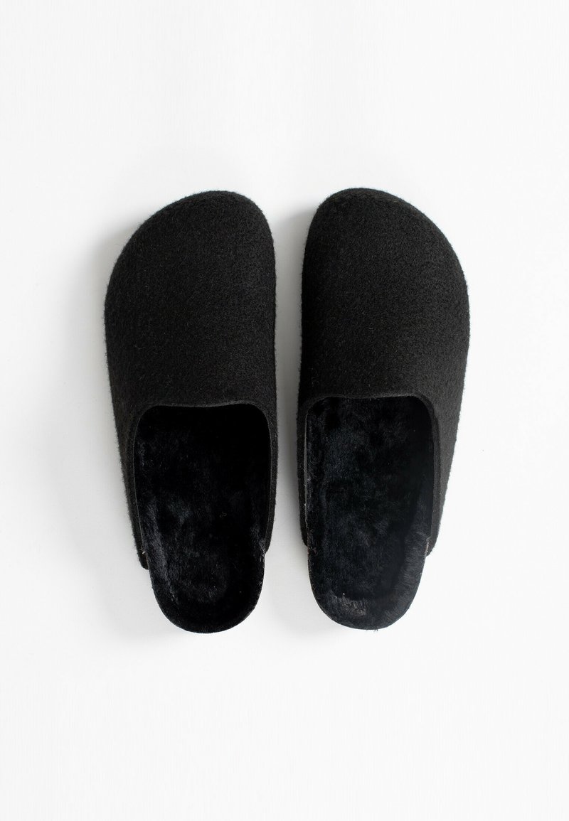 Pantofle di feltro nere con un morbido interno peloso. Design a punta arrotondata, parte superiore liscia e apertura sul retro per una facile vestibilità. Nessun hardware o motivo visibile.