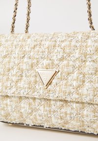 Borsa a tracolla intrecciata in crema e oro con una finitura testurizzata, caratterizzata da una placca logotipica triangolare in tonalità oro e doppi manici a catena.